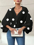 Polka dot, loose-fitting, puff-sleeved top with a semi-open collar.