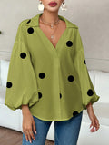 Polka dot, loose-fitting, puff-sleeved top with a semi-open collar.