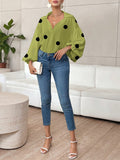 Polka dot, loose-fitting, puff-sleeved top with a semi-open collar.