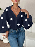 Polka dot, loose-fitting, puff-sleeved top with a semi-open collar.